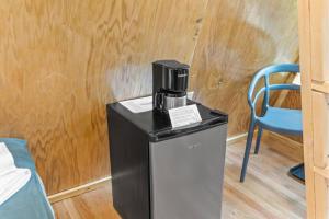 a coffee maker sitting on top of a refrigerator at A-Frames Under the Canopy - Multi-Cabin Retreat in Pine Ridge