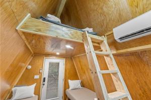 a tiny house with a bunk bed and a ladder at A-Frames Under the Canopy - Multi-Cabin Retreat in Pine Ridge