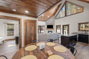 a dining room with a table and a kitchen at Anchor Point- Hot Tub, Firepit, Ping Pong in Rogers