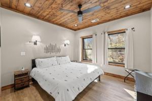 a bedroom with a bed and a wooden ceiling at Anchor Point- Hot Tub, Firepit, Ping Pong in Rogers