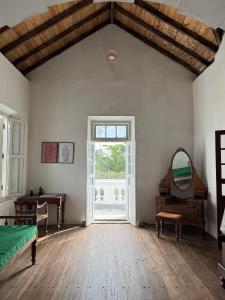 a room with a window and a bed and a mirror at Villa de Zoysa Yoga, Wellness & Waves in Busse +75 photos