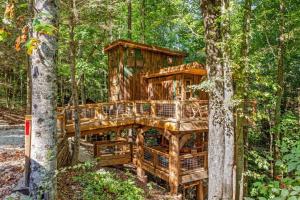 a tree house in the middle of the forest at Amazonia- Pet Friendly, Firepit, Outdoor Shower in Pine Ridge
