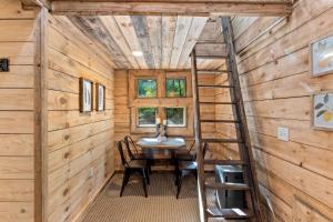 a dining room with a ladder in a tiny house at Amazonia- Pet Friendly, Firepit, Outdoor Shower in Pine Ridge +26 photos