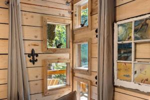 a wall of windows in a log cabin at Amazonia- Pet Friendly, Firepit, Outdoor Shower in Pine Ridge