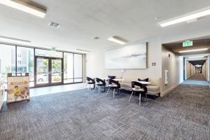 a waiting room with chairs and a projection screen at 2 Mi to UF Campus! Modern Luxury Apt w/ Pool in West Hills +17 photos