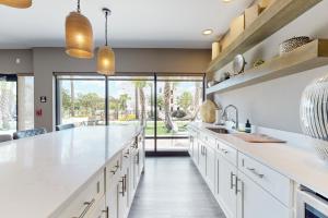 a kitchen with white countertops and a large window at 2 Mi to UF Campus! Modern Luxury Apt w/ Pool in West Hills