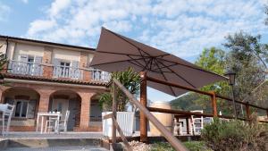 a large umbrella in front of a house at Cà VENDALIS Agriturismo & Cantina in Cinto Euganeo