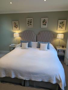 a bedroom with a large white bed with blue pillows at Dunvegan Steading Bed and Breakfast in Dunvegan