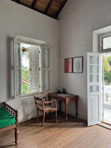 a room with a desk and a chair and a window at Villa de Zoysa Yoga, Wellness & Waves in Busse