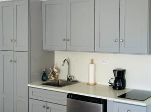 a kitchen with white cabinets and a sink at Deja-Blue studio-pool in Simpson Bay