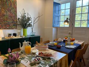 a dining room with a table with food on it at Pensão Destino in Castelo de Vide