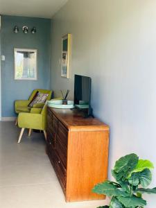a living room with a tv on top of a wooden dresser at Deja-Blue studio-pool in Simpson Bay