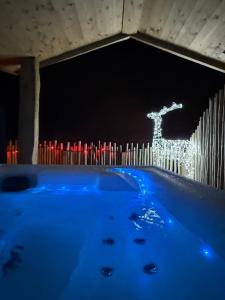 a tub with a statue of a reindeer on a fence at Coeur de Lodge spa privatif in Cramoisy