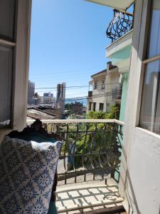 a balcony with a pillow and a view of a city at Casa Mackenna in Valparaíso +5 photos