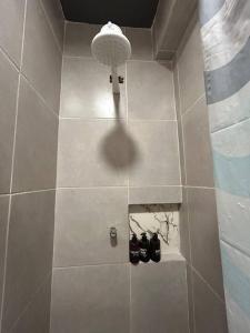a bathroom with a shower with two pairs of shoes at Mini Suite Sossego in Garanhuns