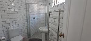 a white bathroom with a toilet and a sink at Jetty Self-Catering in Swakopmund +110 photos