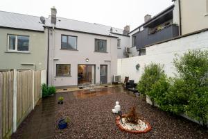 a backyard of a house with a courtyard with a fence at Renada Cottage - Dingle Town Centre in Dingle