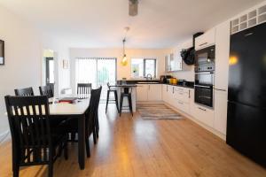a kitchen with a table and chairs and a black refrigerator at Renada Cottage - Dingle Town Centre in Dingle