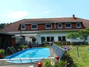 a swimming pool in front of a house at Land-Hotel Am Wald Garni in Greiz