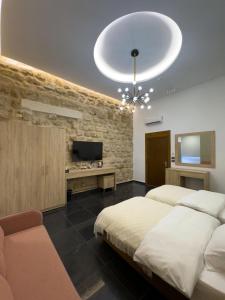 a bedroom with a large bed and a television at Villa Rosa Luxury Boutique Hotel in Batroûn