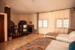 a bedroom with two beds and a fireplace at Dar Arraha Ouirgane in Ouirgane