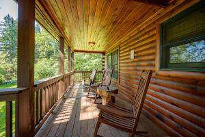 a porch of a cabin with chairs and a table at R & R Cabin by Railey Vacations in McHenry