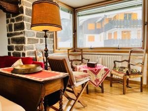 a living room with a table and chairs and a window at GuestHost - Il Dente del Gigante in Courmayeur