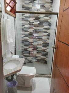 a bathroom with a toilet and a sink and a shower at Pousada Jubarte in Serra