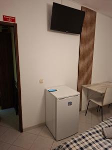 a small white refrigerator in a room with a table at Eucalipto in Faro