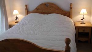 a bedroom with a large white bed with two lamps at Normalie in Villarodin-Bourget