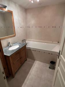 a bathroom with a sink and a bath tub at Normalie in Villarodin-Bourget