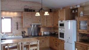 a kitchen with wooden cabinets and a white refrigerator at Normalie in Villarodin-Bourget