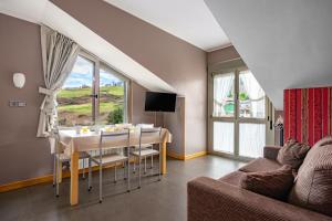 a living room with a table and a couch at Apartamentos Spa Cueto in Cangas de Onís