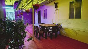 a table and chairs in a room with purple lights at Angel's Cottage in Munnar +25 photos