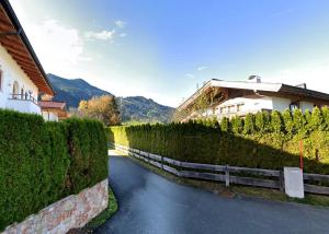 a path through a hedge next to a building at MountainRelaxKtzh in Kitzbühel