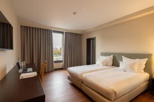 a hotel room with a bed and a desk with a laptop at Hotel Premium Porto Maia in Maia +64 photos