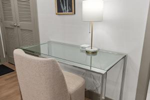 a glass desk with a chair and a lamp at Brick & Bed Riverfront Lofts, T 305 in Saint Louis +4 photos