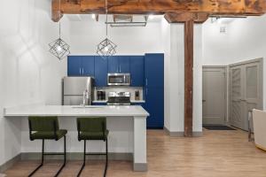 a kitchen with blue cabinets and a white counter top at Brick & Bed Riverfront Lofts, T 305 in Saint Louis