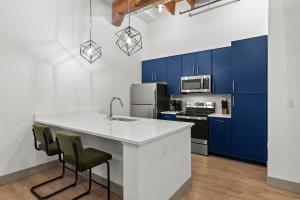 a kitchen with blue cabinets and a white counter top at Brick & Bed Riverfront Lofts, T 305 in Saint Louis