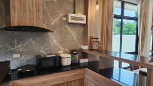 a kitchen with a counter top with a microwave at Pana Villa Koh Lanta in Ban Ai Dao