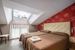 a bedroom with two beds and a large window at Apartamentos Spa Cueto in Cangas de Onís +84 photos