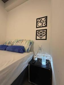 a bedroom with a bed and a table with a lamp at Mini Suite Comforto in Garanhuns