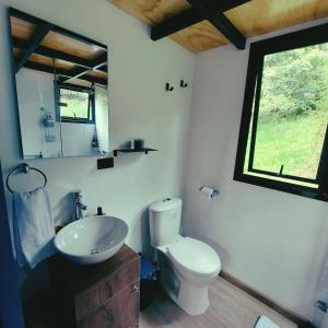 a bathroom with a toilet and a sink and a window at La Tiny TINY HAUS in Bogotá
