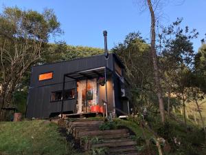 a black tiny house in the woods at La Tiny TINY HAUS in Bogotá