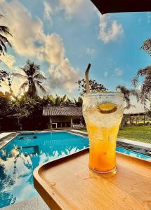 a glass of beer sitting on a table next to a pool at Idam Villa in Akmimana