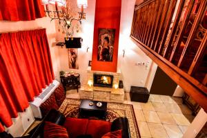 sala de estar con cortinas rojas y chimenea en Camelia Suites en Synikia Mesi Trikalon