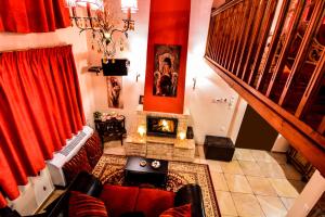 a living room with red curtains and a fireplace at Camelia Suites in Synikia Mesi Trikalon