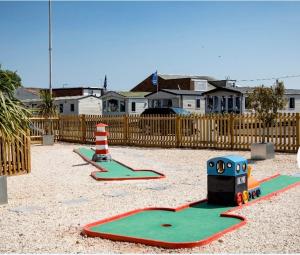 a playground with two play equipment in the sand at Blanco's by the sea in Saint Osyth