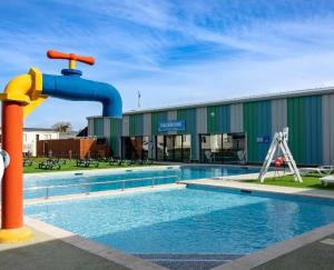 a swimming pool with a water fountain in front of a building at Blanco's by the sea in Saint Osyth