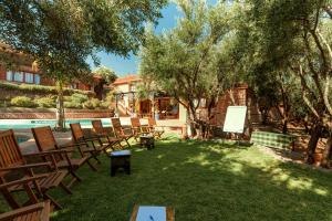 a yard with chairs and a pool and trees at Dar Arraha Ouirgane in Ouirgane